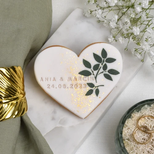 Ciasteczko maślane obłożone białym lukrem z lukrowanymi listkami.