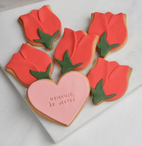 Zestaw maślanych ciasteczek, zdobionych lukrem, tworzących słodki bukiet jadalnych tulipanów.