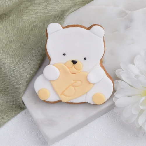 Ciasteczko w kształcie białego misia z serduszkiem.