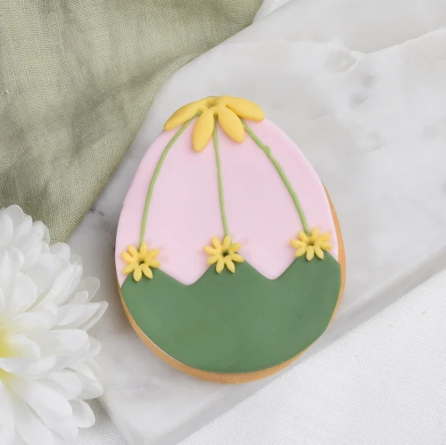Ciasteczko lukrowane w kształcie jajka wielkanocnego z wiosennym zdobieniem.