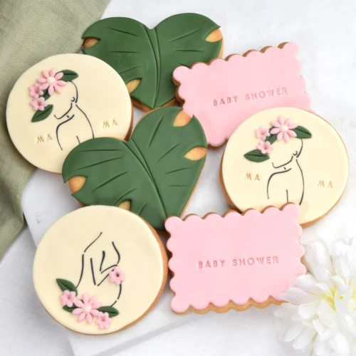Zestaw ciasteczek na Baby Shower z zarysami kobiecej sylwetki z brzuszkiem.
