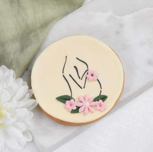 Lukrowane ciasteczko na Baby Shower z zarysem brzuszka.