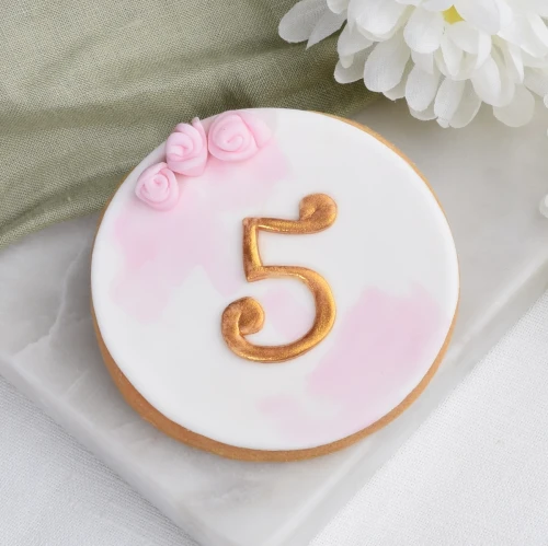 Ciasteczko lukrowane ze złotą cyferką.