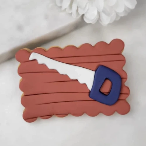 Ciastko lukrowane z motywem drewna i piły.