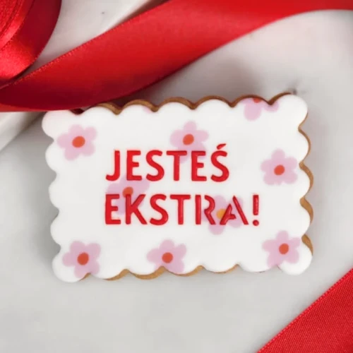 Ciasteczko w kwiatki z napisem Jesteś Ekstra.
